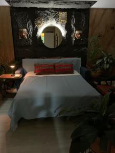 a bedroom with a bed with a mirror on the wall at Ma maison peruvienne- departamento muy cerca aéropuerto in Lima