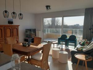 a living room with a table and a couch at Appartement Bootsman prachtig zicht, groot zonnig terras, garage, fietsenberging OOSTENDE FIETSSTAD - ENSORSTAD in Ostend