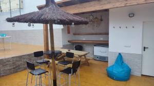 a table with chairs and a large umbrella at Geranio Chipionahome in Chipiona