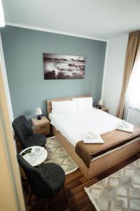 ボルシャにあるCasa Gabiのベッドと椅子2脚のある寝室