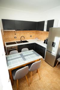 ボルシャにあるCasa Gabiのテーブルと椅子と冷蔵庫のあるキッチン +14枚の写真