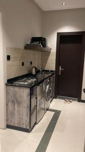 a kitchen with a stove and a washing machine at شقق ثري ستار للشقق المخدومة in Riyadh