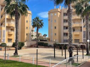 a parking lot with palm trees in front of a building at Casa Cabo Palos in Cabo de Palos