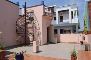 a pink house with a gate and a balcony at Kasotiya Mansion Homestay in Surūrnagar