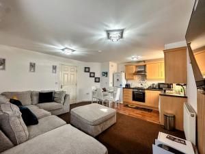 a living room with a couch and a kitchen at 2Bedroom Gem at Golborne, Warrington with Free Parking - Contractor Friendly in Golborne
