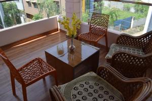 a balcony with chairs and a table with a vase of flowers at Kasotiya Mansion Homestay in Surūrnagar