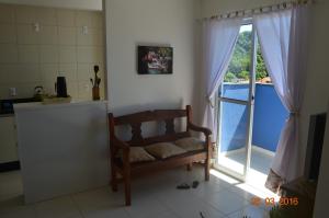 a living room with a bench and a window at Residencial Lunata in Penha