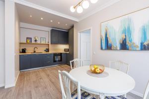 a kitchen and dining room with a white table and chairs at Harmony Apartment in Riga