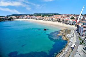 an aerial view of a beach with a boat in the water at 1ª línea playa de Silgar en Sanxenxo, a 20 pasos in Sanxenxo