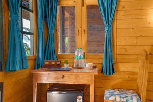 un tavolo in legno in una stanza con tende blu di Parisa beach resort Tarkarli Bhogwe a Malwan