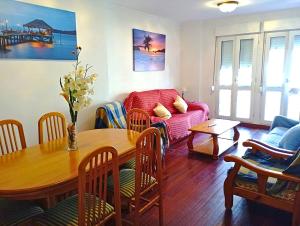 a living room with a table and a couch at 1ª línea playa de Silgar en Sanxenxo, a 20 pasos in Sanxenxo
