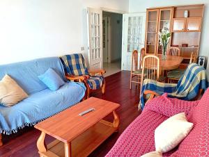 a living room with a blue couch and chairs at 1ª línea playa de Silgar en Sanxenxo, a 20 pasos in Sanxenxo +22 photos