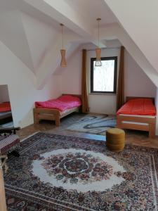 ein Dachzimmer mit zwei Betten und einem Teppich in der Unterkunft Pelister Riverside Villa in Bitola