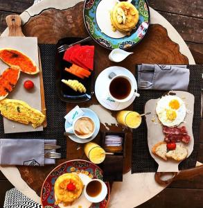 a table with plates of breakfast food and cups of coffee at The White Key Luxury Villas in Gili Trawangan