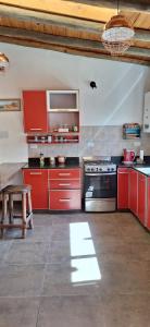a kitchen with red cabinets and a stove at Cabañas La Ekeka in Tilcara +29 photos