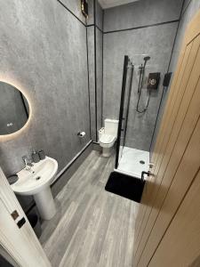 un bagno con doccia, lavandino e WC di Stunning Sea View Apartment With Balcony & Parking a Rhos-on-Sea
