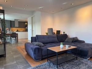 a living room with a blue couch and a table at Apartment Bacci in Vrhnika