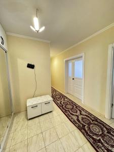 una stanza vuota con una porta e un pouf bianco di Квартира в аренду береке a Tridtsatʼ Let Kazakhstana Altre 2 foto