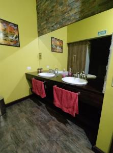 a bathroom with two sinks with red towels at Posada Alma del Cerro in El Calafate +54 photos