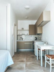 a kitchen with white cabinets and a white table at Cycladic Stone Studio in Ambelas
