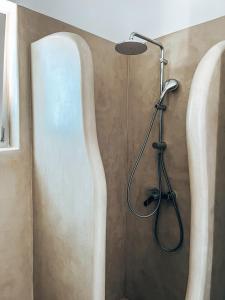 a shower with a shower head in a bathroom at Cycladic Stone Studio in Ambelas