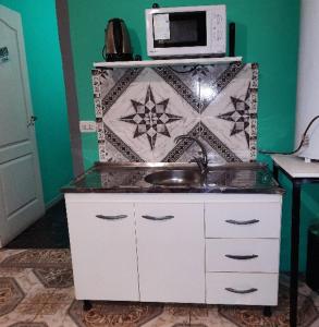 リオ・ガジェゴスにあるMoni Moni Cのシンクと電子レンジ付きのキッチン