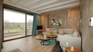 a living room with a couch and a large window at Philia Luxury Living in Nei Poroi