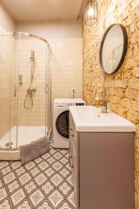 a bathroom with a shower and a sink and a tub at Amber Apartment in Riga +16 photos