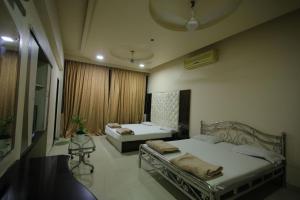 a bedroom with two beds and a window at Hotel Shubhkarta in Akola