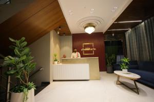 a woman standing at a counter in a lobby at Hotel Shubhkarta in Akola