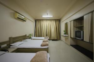 a hotel room with two beds and a tv at Hotel Shubhkarta in Akola +16 photos