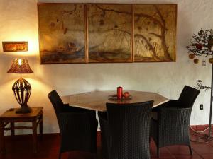 une table à manger avec des chaises et un tableau mural dans l'établissement El Refugio, à Foz do Iguaçu