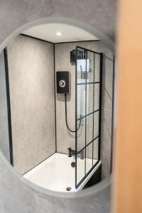 una doccia in un bagno con uno specchio di Stunning 2 Bedroom Beach Apartment With Garden a Rhos-on-Sea