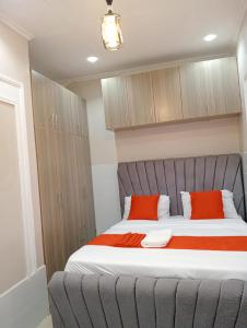a bedroom with a large bed with two red pillows at Lora's Haven Homes, Nakuru - 1 Bedroom in Nakuru