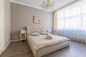a bedroom with a large bed and a chandelier at Amber Apartment in Riga