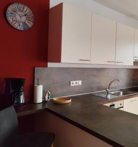 Una cocina con gabinetes blancos y un reloj en la pared. en Apartment 66 - stylisches Apartment mit Balkon & Toplage in Brixen, en Bresanona