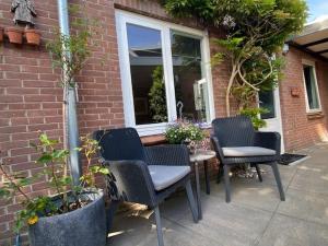 un patio con sillas, una mesa y una ventana en BY BABS guesthouse Bergen nh, en Bergen