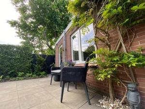 un patio con 2 sillas, una mesa y una ventana en BY BABS guesthouse Bergen nh, en Bergen