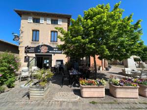 a building with tables and chairs and trees and flowers at Douce Escapade à Chaintré in Chaintré