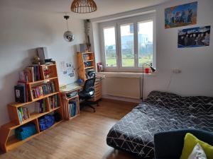 a bedroom with a bed and a desk and a window at Bienvenue à la maison ! in Mulsanne
