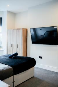 ein Schlafzimmer mit einem Flachbildfernseher an der Wand in der Unterkunft Modern 5 Bedroom Terraced Luxurious House in Colwyn Bay