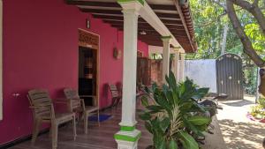 a pink house with chairs and a porch at Vista villa in Panama