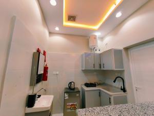 a small kitchen with white cabinets and a sink at مرفق الشلال السياحي in Jeddah
