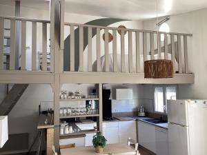 a kitchen with a staircase and a white refrigerator at Le gite de lOlivier en Provence in Aramon