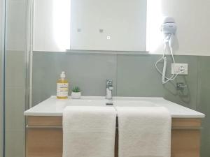 ein Waschbecken mit einem Handtuch. in der Unterkunft QUEEN HOME VENICE TRAIN STATION Noemi & Angel in Venedig