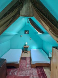 twee bedden in een kamer met blauwe muren bij Villa de la fontaine vue mer in Paimpol