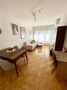 a living room with a table and a couch at City Garden Apartment in Plovdiv