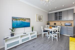 a kitchen and dining room with a table and a tv at Elegant Apartment in Riga
