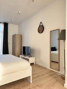 a bedroom with a bed and a mirror at Bora Apartment in Brussels