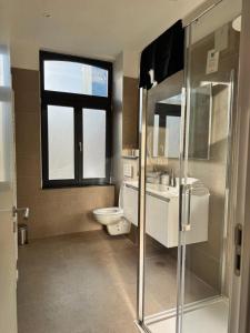 a bathroom with a sink and a toilet and a window at Bora Apartment in Brussels +12 photos